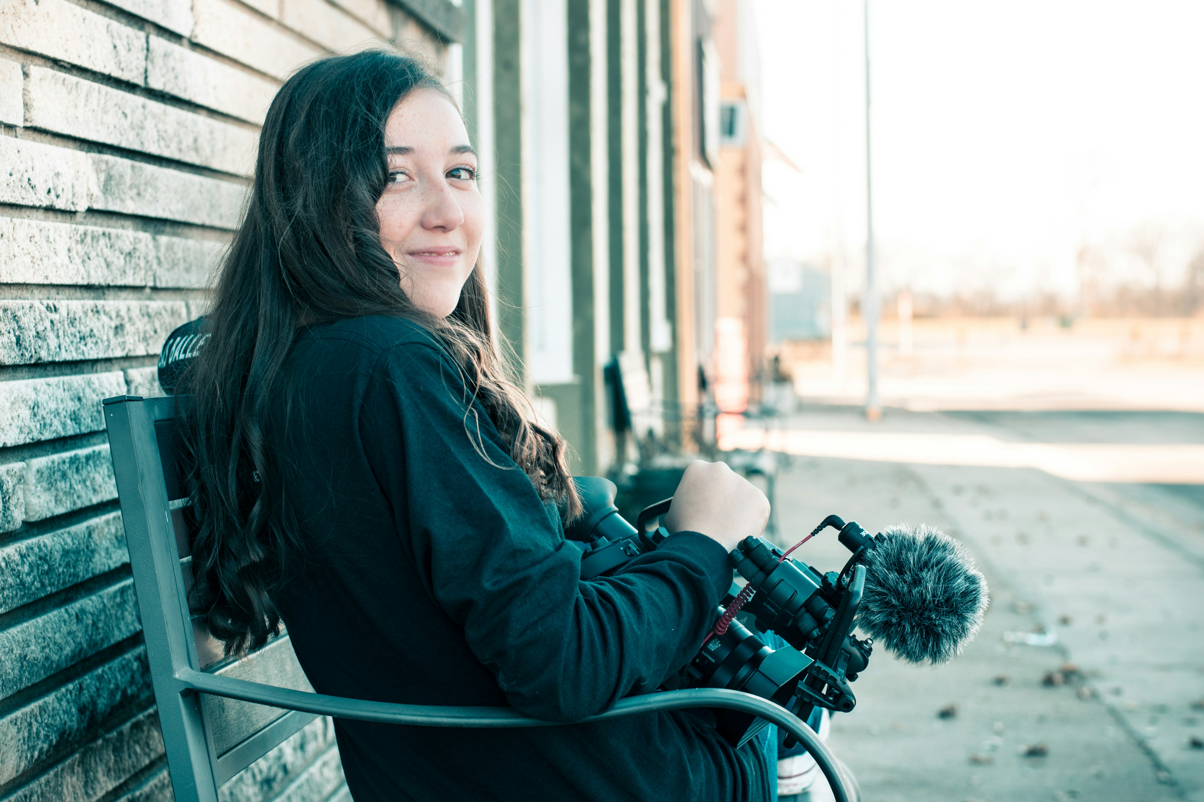 smiling woman sitting on bench at daytime